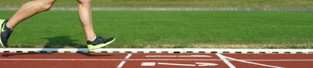 Eine Person läuft auf einer Laufbahn